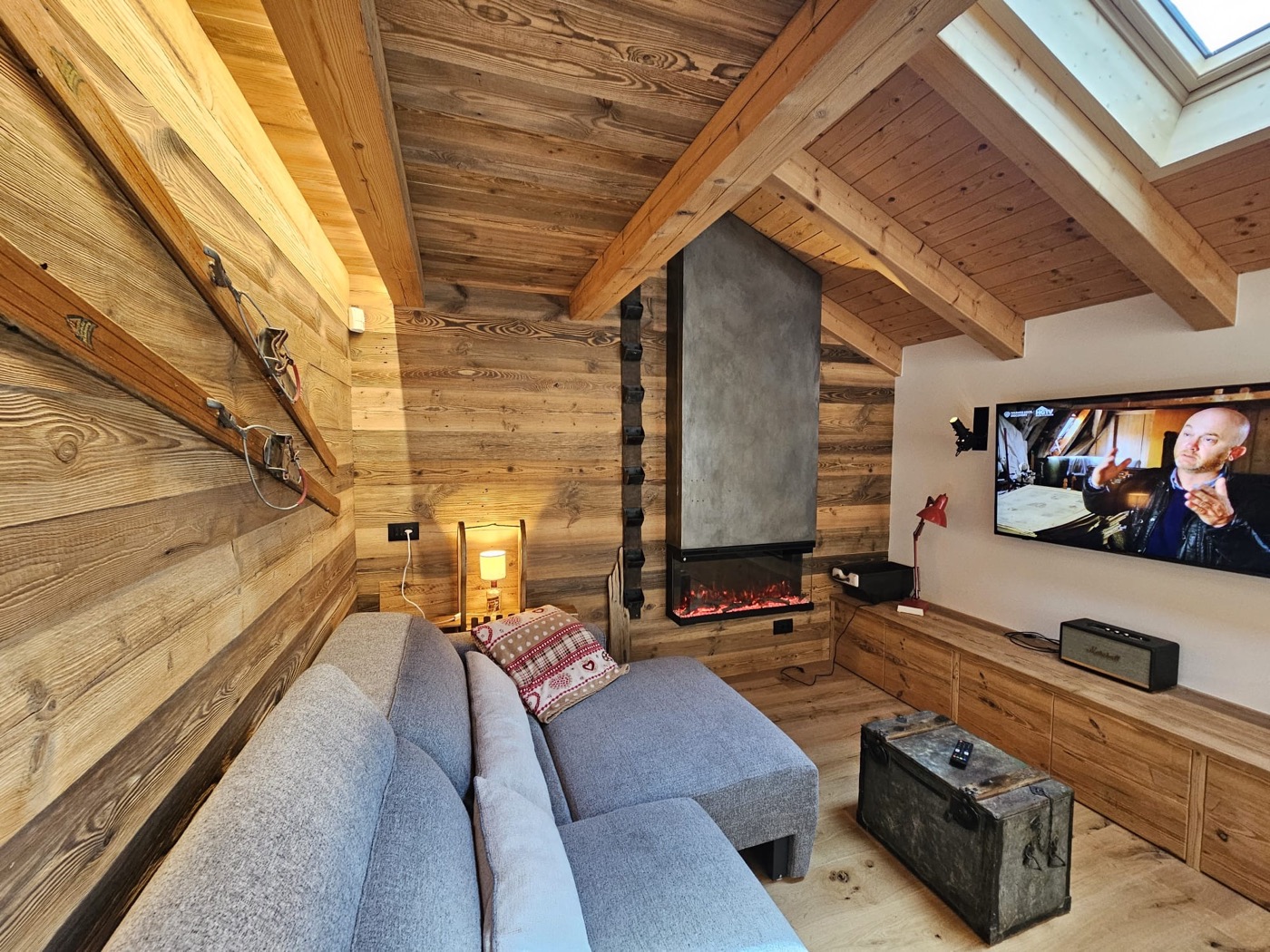 Zona relax con camino, sci a parete e angolo TV
